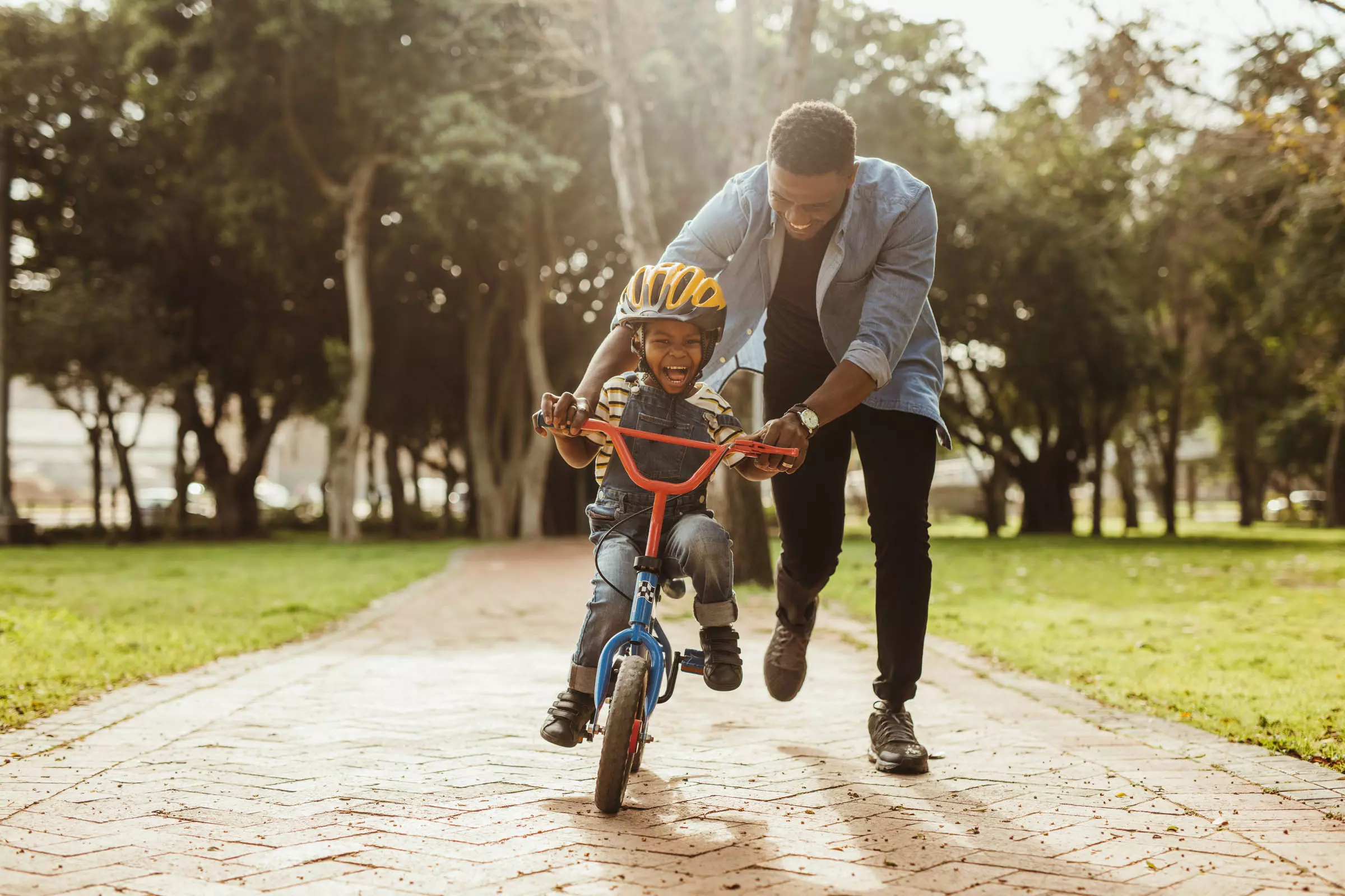 parent teaching child to ride bike